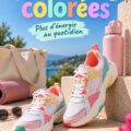 Une femme souriante portant des baskets colorées pendant une séance d'entraînement à l'extérieur.